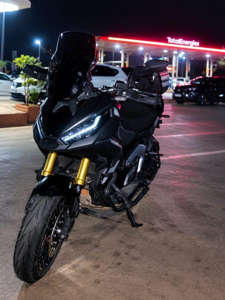 Honda X-ADV noir de nuit dans une station-service, location moto à Marrakech